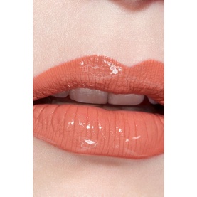 Close-up of lips wearing Chanel Ultra Wear Liquid Lip Colour in Beige Chic 164, showing a glossy coral-nude finish