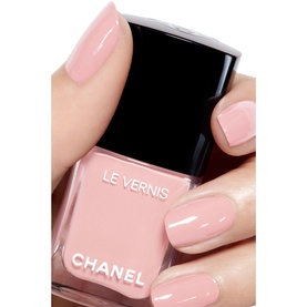 Chanel Le Vernis nail varnish in sheer pink, held by model with matching manicured nails