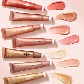 Charlotte Tilbury Beauty Lightwand collection in multiple shades, shown as tubes with cream swatches on a pink background