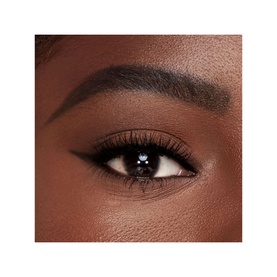 Close-up of model's eye showing Charlotte Tilbury Brow Cheat in Natural Black, defining brows with precise, hair-like strokes