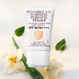 Charlotte Tilbury Invisible UV Flawless Poreless Primer SPF 50 PA++++, white tube, styled with flowers and green leaves.