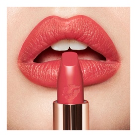 Charlotte Tilbury Hot Lips 2.0 Refill lipstick in Carina's Star, a warm coral-pink shade, shown applied on model's lips with bullet visible