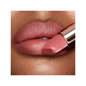 Model with Charlotte Tilbury Matte Revolution Refill lipstick in Wedding Belles, a muted rose-pink shade, applied to lips