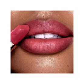 Model with Charlotte Tilbury Matte Revolution Refill in First Dance, a deep rose-pink matte lipstick applied to full lips