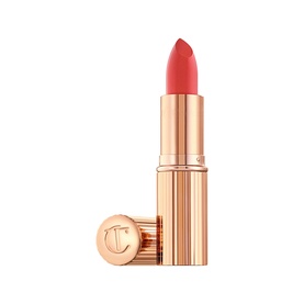Charlotte Tilbury KISSING Lipstick in Yes Honey, a warm coral-red bullet with gold ribbed case and engraved cap