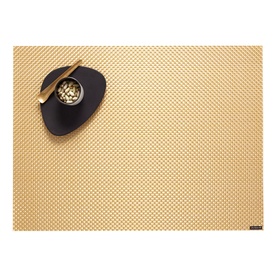 Chilewich Basketweave Placemat in gold woven vinyl, styled with a dark bowl and gold utensils on top