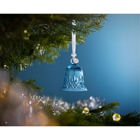 Waterford Christmas Bell Ornament Topaz Ice, blue crystal bell with cut detailing, hanging from Christmas tree with white ribbon