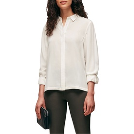Model wearing Whistles Classic Silk Shirt in white, styled with dark trousers and carrying a navy clutch bag