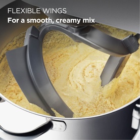 Kenwood Chef Flex Beater mixing creamy batter in a stainless steel bowl, showing flexible silicone-edged wings for smooth blending
