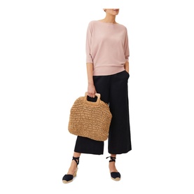 Model wearing Phase Eight Cristine Fine Knit Sweater in pink, styled with black wide-leg culottes and espadrille wedges, carrying a woven straw bag