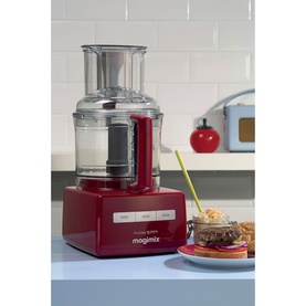 Magimix Cuisine Systeme 5200 XL food processor in red with clear bowl and lid, styled in a kitchen setting with food nearby