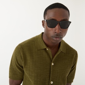 Model with Dolce & Gabbana 0DG6145 Square Sunglasses in black, styled with an olive green textured knit short-sleeve shirt