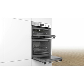 Bosch Serie 4 Built-In Double Oven in stainless steel, lower door open, installed in white cabinetry with wooden floor visible