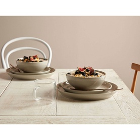 Denby Intro 12-Piece Tableware Set in beige stoneware, styled on a wooden dining table with bowls and plates containing food