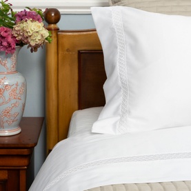 Piubelle Diamantine Housewife Pillowcase Pair in cream with delicate lace trim detail, styled on a bed with white bedding and wooden headboard