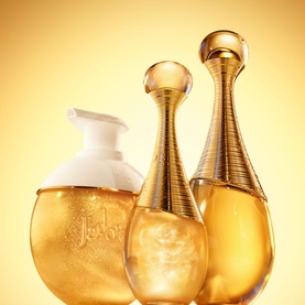 Dior J'adore Shimmering Hair Mist in gold bottle displayed alongside J'adore eau de parfum and body lotion on golden background
