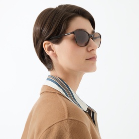 Model wearing Emporio Cat Eye Sunglasses EA4073 in brown, styled with a camel blazer and striped collar top