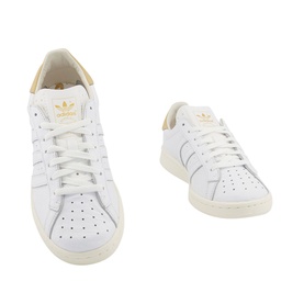 Adidas Earlham Trainers in white leather with gold trefoil logo, perforated sides, white laces, and cream sole, shown in two angles