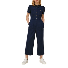 Model wearing Whistles Emma Pocket Detail Jumpsuit in blue, short sleeve, wide-leg crop, gold buttons, styled with white trainers