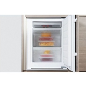Whirlpool 70-30 Integrated Fridge Freezer freezer compartment open, showing shelved interior with stored food containers