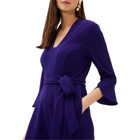 Model wearing Phase Eight Eydie Fluted Sleeve Jumpsuit in blue, featuring V-neck, 3/4 fluted sleeves and belt tie waist detail