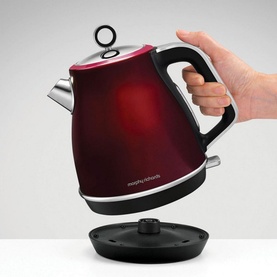 Morphy Richards Evoke Jug Kettle 1.5L in deep red metallic finish, being lifted from black base by a hand
