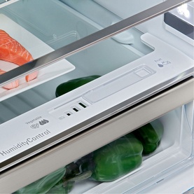 Hotpoint Freestanding Fridge Freezer in silver, close-up of HumidityControl drawer with fresh vegetables and salmon visible inside