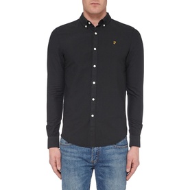 Model wearing Farah Vintage Brewer Slim Fit Shirt in black, long-sleeve button-down with logo embroidery, styled with blue jeans