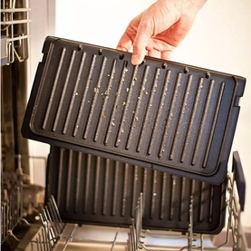 Russell Hobbs Large 5 Portion Health Grill removable black plates being placed into a dishwasher, showing easy cleaning feature