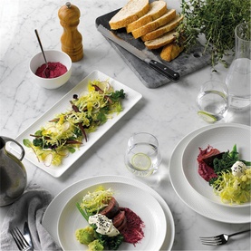 Wedgwood Gio Rectangular Tray 21cm in white bone china, styled on marble surface with salad dish, surrounded by coordinating Gio tableware and food