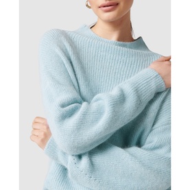Model wearing Forever New Hester Rib Knit Sweater in blue, showing relaxed fit, stand neck, and eyelet detail on deep cuffs