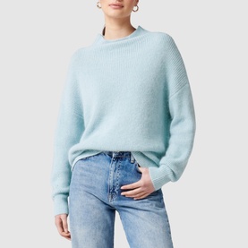 Model wearing Forever New Hester Rib Knit Sweater in blue with stand neck and deep cuffs, styled with light-wash jeans