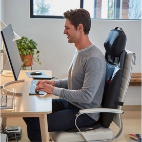Homedics 2-in-1 Shiatsu Massaging Seat Topper in use on office chair, man seated at desk typing on keyboard