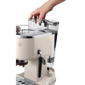 Delonghi Icona Vintage Traditional Pump Espresso Machine in cream, hand removing the glass water tank from the top of the machine.