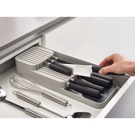 Joseph Joseph DrawerStore Knife Organiser in grey, shown in open kitchen drawer holding knives, with whisk and spoon alongside