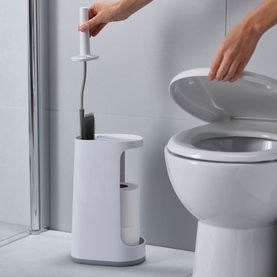 Joseph Joseph Flex Store Toilet Brush with Storage Caddy in grey, shown in use beside toilet, caddy holding spare toilet rolls