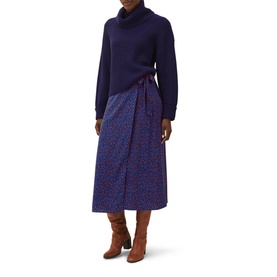 Model wearing Phase Eight Karine Chunky Roll Neck Sweater in blue with a floral wrap midi skirt and tan ankle boots