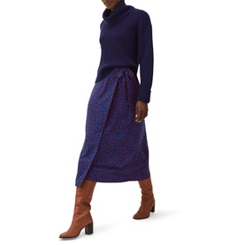 Model wearing Phase Eight Karine Chunky Roll Neck Sweater in blue with a navy leopard-print midi skirt and tan knee-high boots