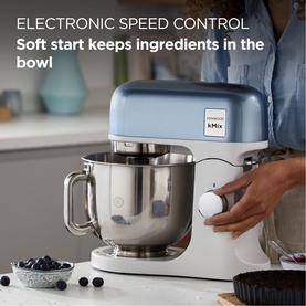 Kenwood kMix Stand Mixer With 5 Litre Bowl in blue, shown in use with stainless steel bowl, blueberries and small bowl alongside