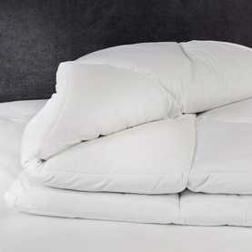 Karla Bree Microfill Supersoft All Seasons Duvet in white, shown folded with a pillow on a bed