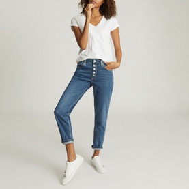 Model wearing Reiss Luana V-Neck T-Shirt in white, styled with mid-blue button-fly jeans and white trainers