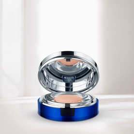 La Prairie Skin Caviar Essence-in-Foundation SPF25 in Petale, open compact revealing nude-toned cushion pan with mirror lid, blue case
