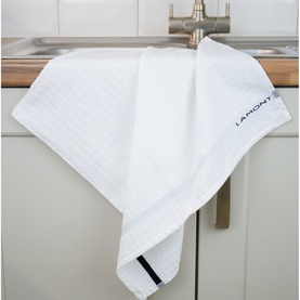 Lamont Poli-Dri White Tea Towel draped over a kitchen sink edge, showing striped texture and navy woven border detail