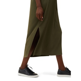 Model wearing Phase Eight Lucina Midi Dress in green, midi length with side split, styled with black leather trainers