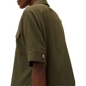 Model wearing Phase Eight Lucina Midi Dress in green, showing textured fabric, short sleeve, collar, and gold logo badge detail