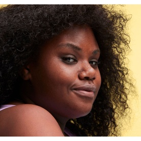 Model with MAC Studio Radiance Face And Body Radiant Sheer Foundation, showcasing a luminous, natural complexion finish on deep skin tone