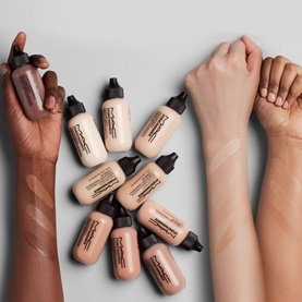 MAC Studio Radiance Face And Body Radiant Sheer Foundation 50ml bottles grouped on three arms showing sheer foundation swatches across multiple skin