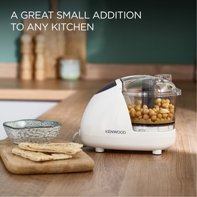 Kenwood Mini Chopper in white, 350ml capacity, shown on wooden board with chickpeas inside, beside crackers and a bowl.