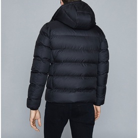 Model wearing Reiss Meyrim Padded Jacket in blue, rear view, with attached hood and quilted panels, styled with dark jeans