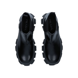 Prada Monolith XL Chelsea Boots in black leather, overhead view showing chunky rubber lug sole and elasticated side panels